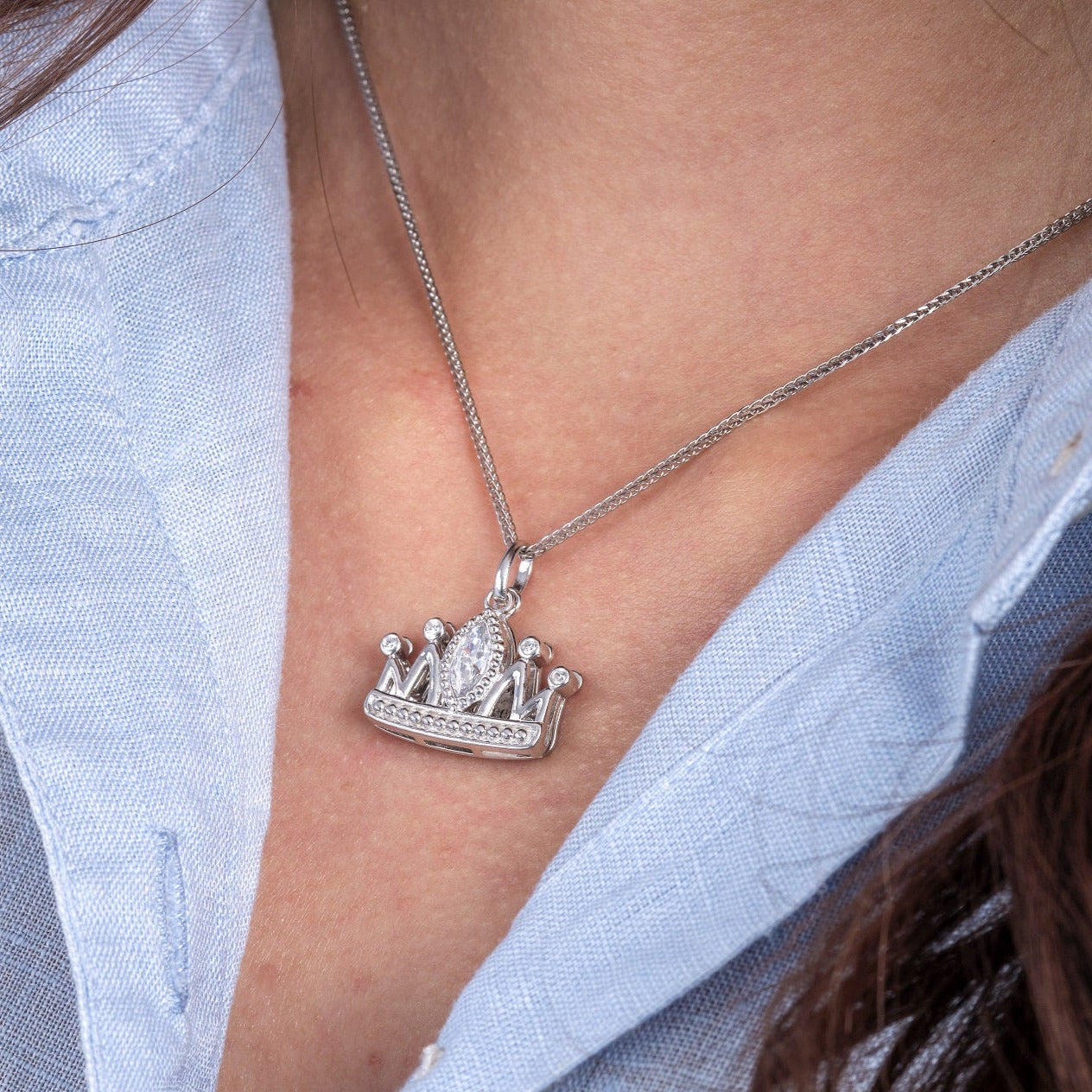 Close up shot of model wearing Mom Crown necklace pendant.